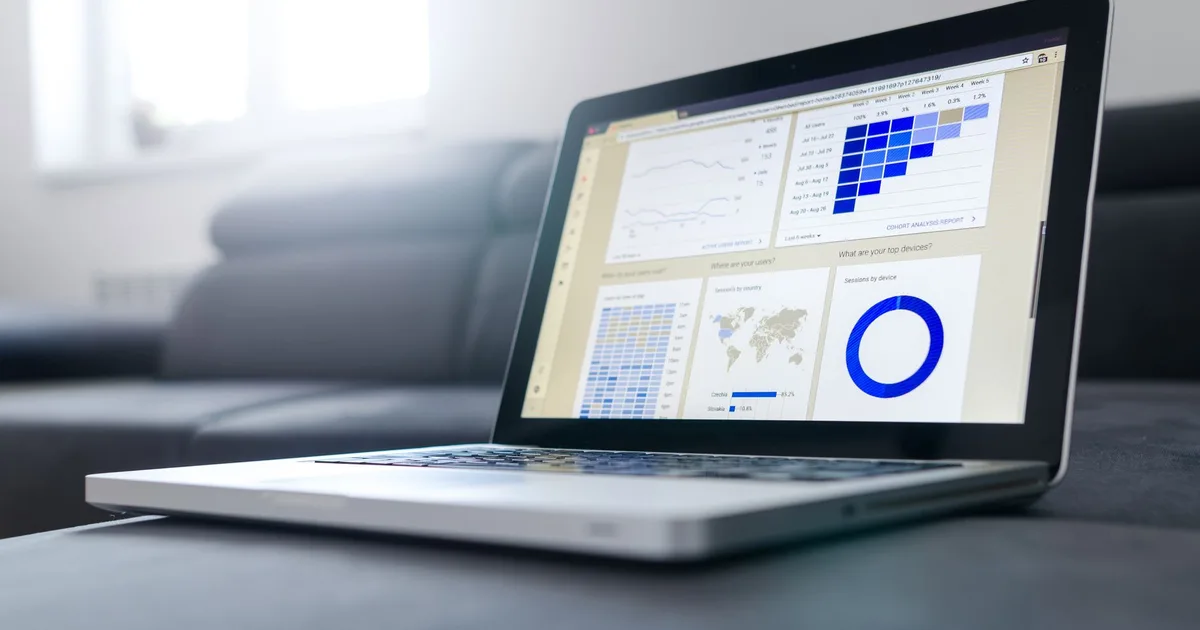 Laptop mostrando gráficos de análisis de datos en pantalla, en una sala luminosa