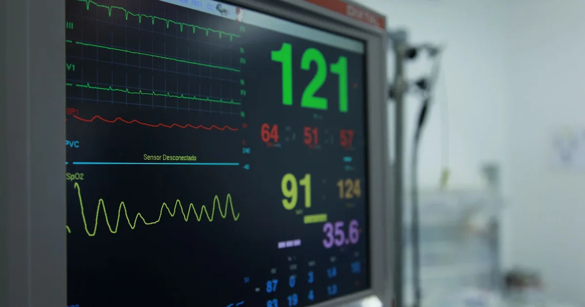 Primer plano de un monitor de signos vitales mostrando lecturas médicas en un entorno hospitalario