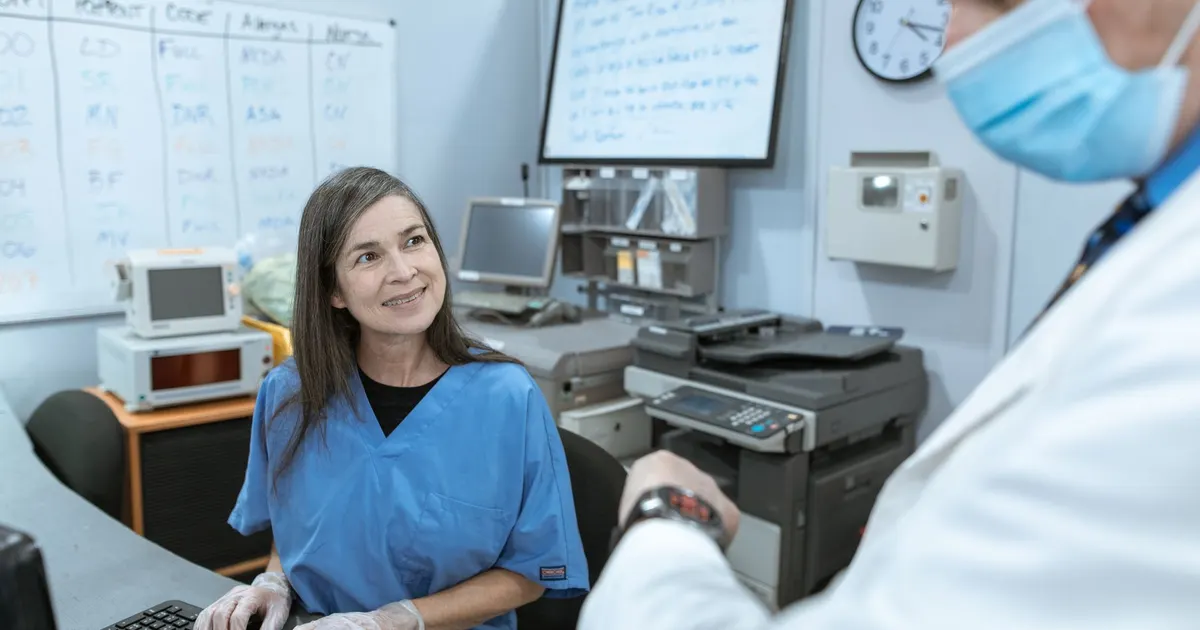 Personal médico colaborando frente a un computador en tareas administrativas de una clínica