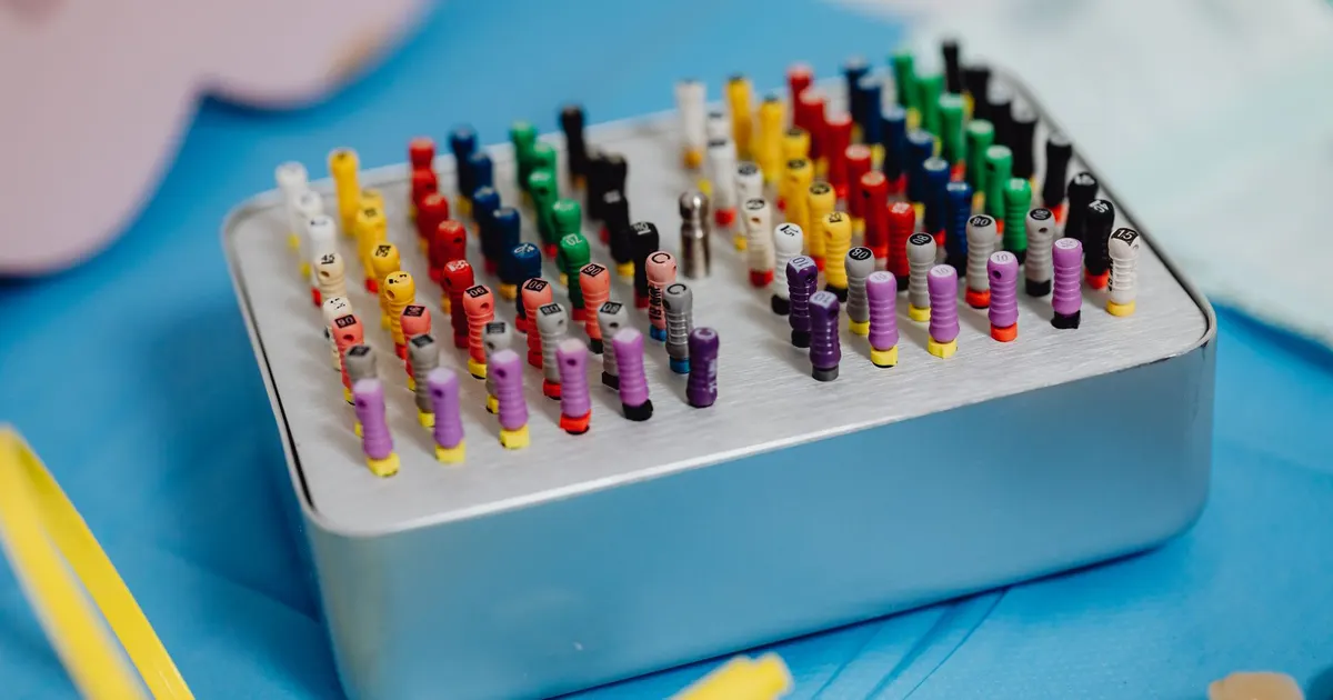 Primer plano de limas de endodoncia de colores ordenadas en una bandeja de esterilización