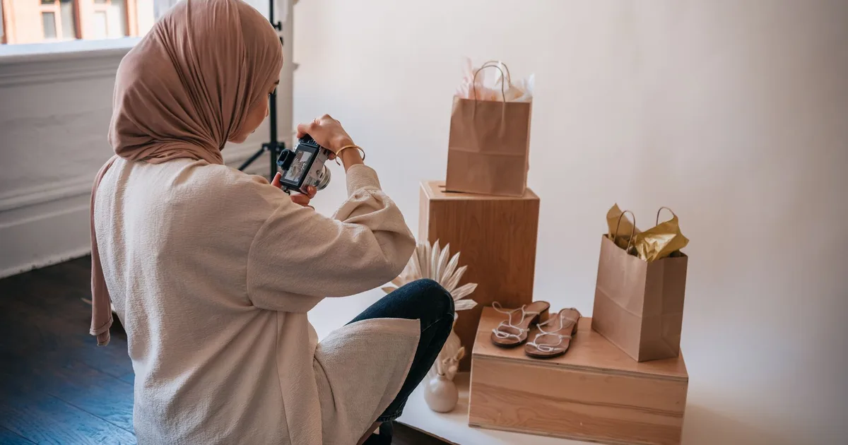 Mujer con hiyab fotografiando productos en un estudio bien iluminado