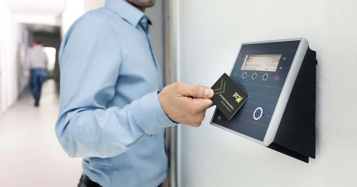 Empleado usando una tarjeta RFID en un lector de acceso en una oficina moderna